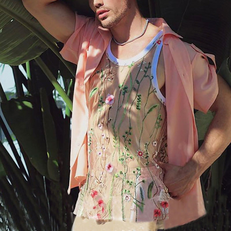 Cropped model wearing a sheer embroidered floral tank under an open pink shirt