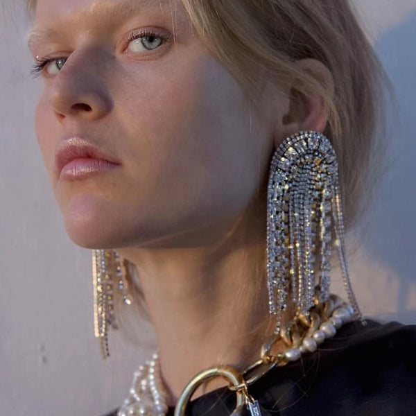 Close-up of a model wearing long silver rhinestone tassel earrings