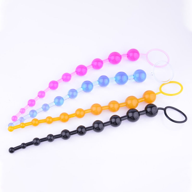 Four graduated anal bead strands in pink, blue, orange, and black, arranged on white