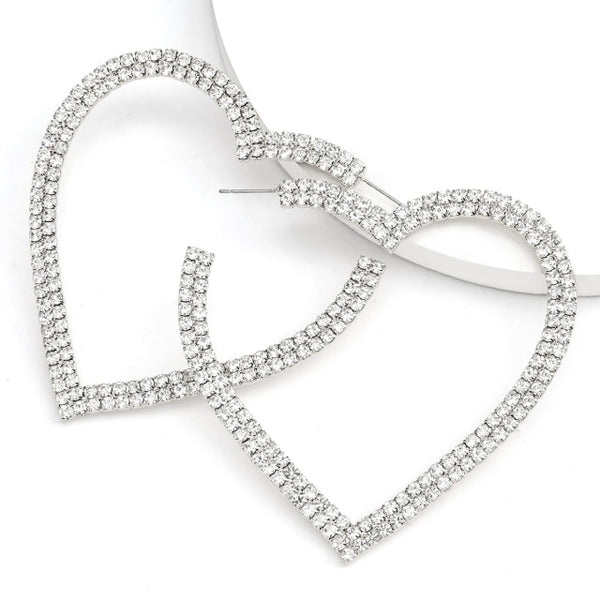 Heart-shaped hoop earrings covered in clear rhinestones, shown crossed on a white background