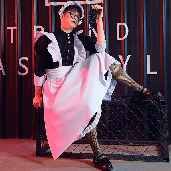 Model wearing a black-and-white French maid costume with apron, ruffles and fishnet stockings