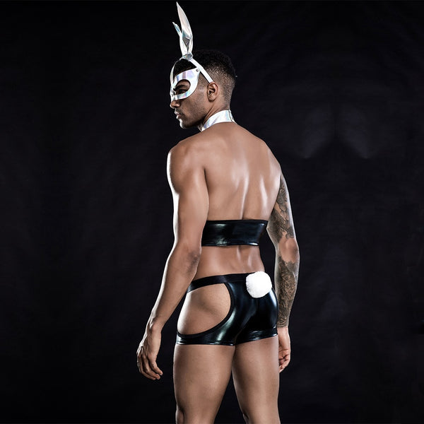 Rear view of a model wearing a black faux-leather bunny costume with open-side shorts and white tail