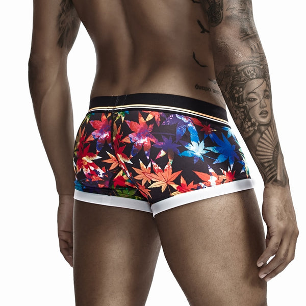 Model wearing black floral boxers with a striped waistband and white leg bands