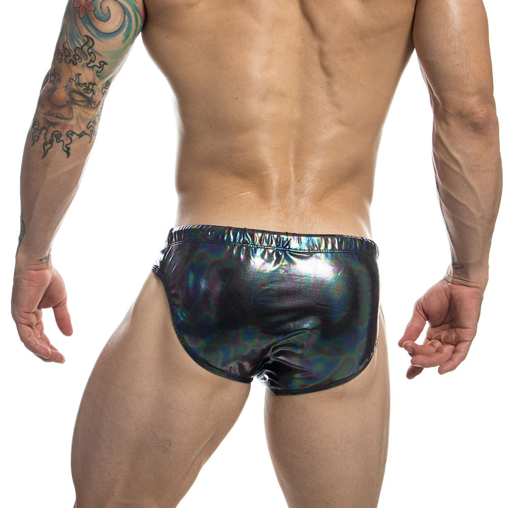 Rear view of a model wearing iridescent black PU leather swim briefs