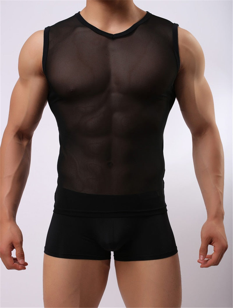 Front view of a muscular model wearing a sheer black mesh muscle tank and black boxer briefs