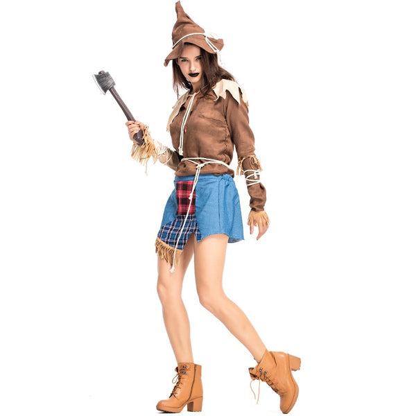 Model in a scarecrow costume with pointed hat, blue skirt, broom, and boots
