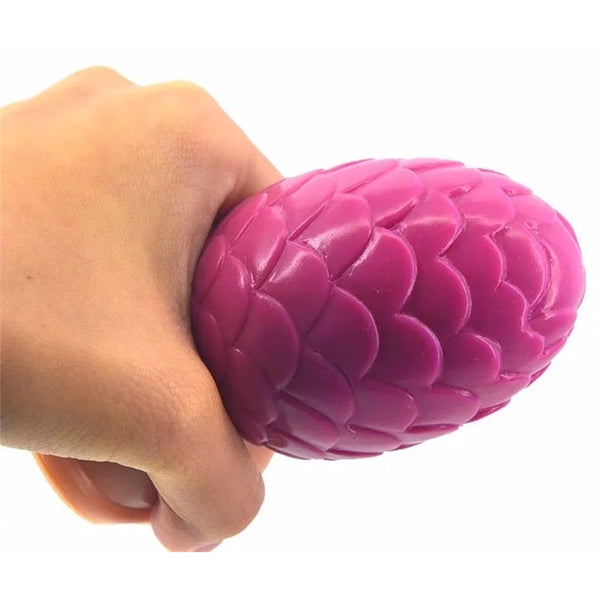 Hand holding a glossy pink lotus-petal anal plug against a white background
