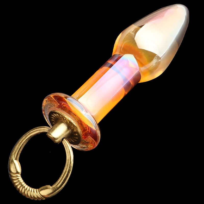 Orange translucent glass butt plug with a rounded tip and gold finger ring