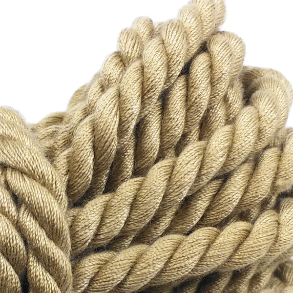 Close-up detail of thick tan braided rope coiled against a white background