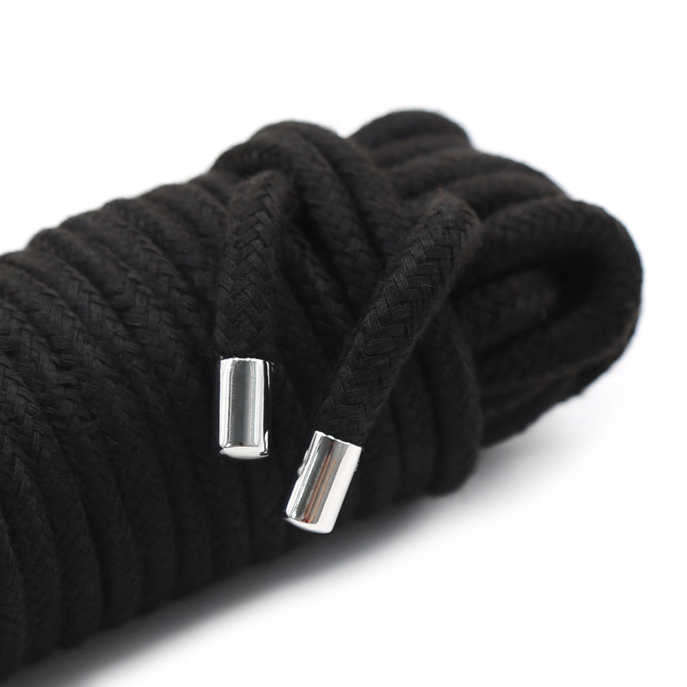 Close-up of coiled black braided rope with two shiny silver end caps on a white background