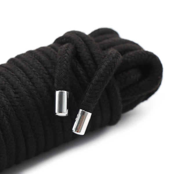 Close-up of coiled black braided rope with two shiny silver end caps on a white background
