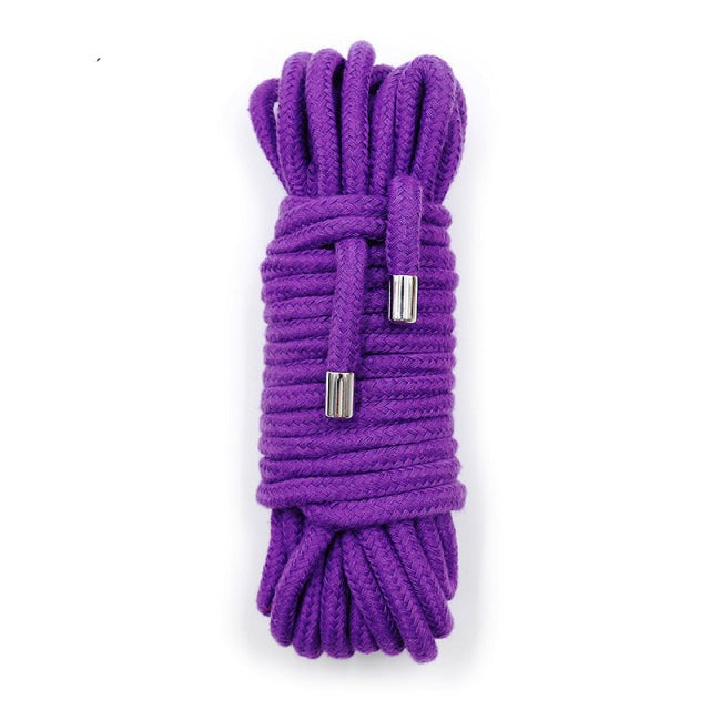 Coiled purple shibari rope with two silver metal-tipped ends on a white background