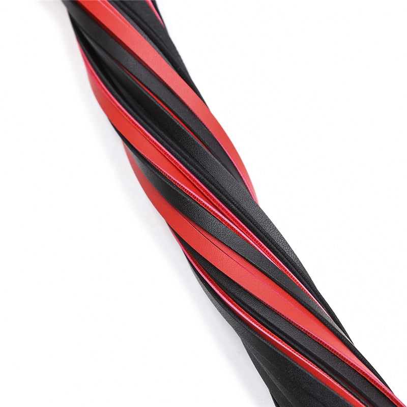 Close-up of a black and red braided erotic whip against a white background