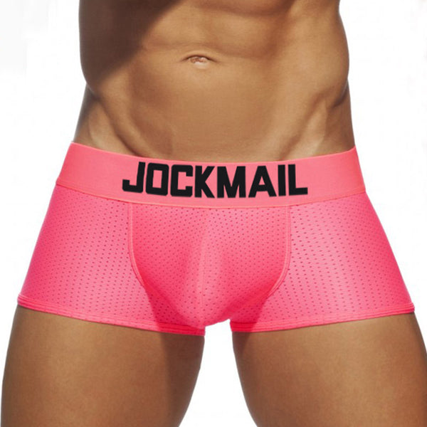 Front view of a model wearing bright pink mesh Jockmail boxer briefs