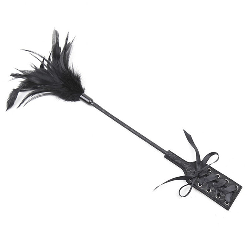 Black feather flogger with a long handle and two lace-up wrist cuffs