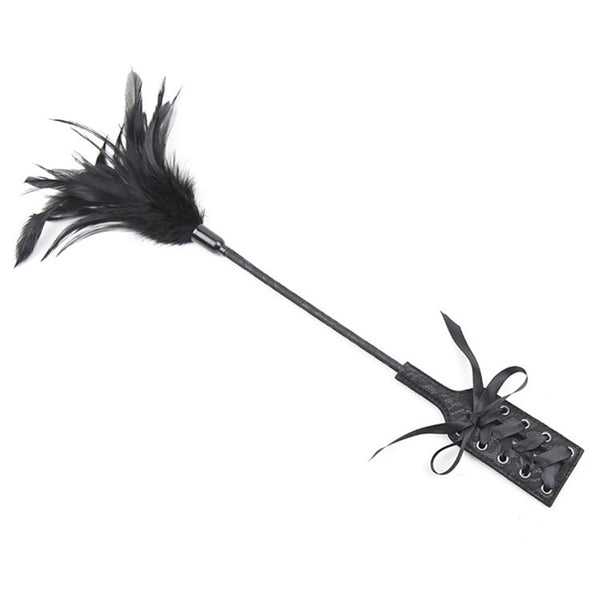 Black feather flogger with a long handle and two lace-up wrist cuffs