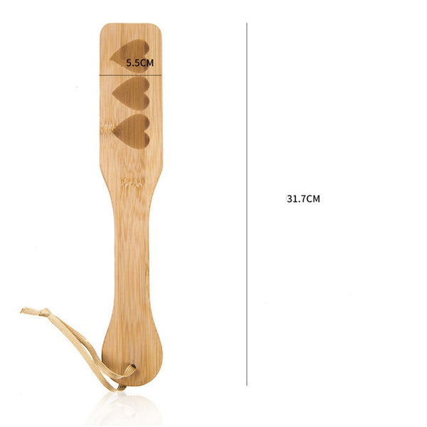 Wooden spanking paddle with three heart cutouts, wrist loop, and 31.7 cm size marking