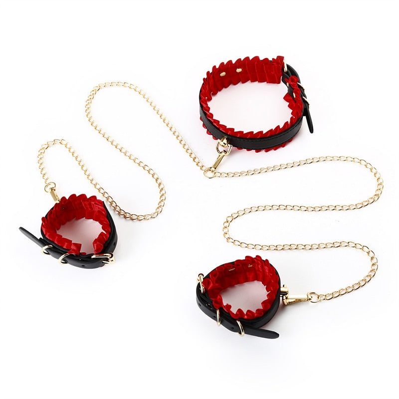 Three black-and-red BDSM cuffs with gold chains arranged on a white background
