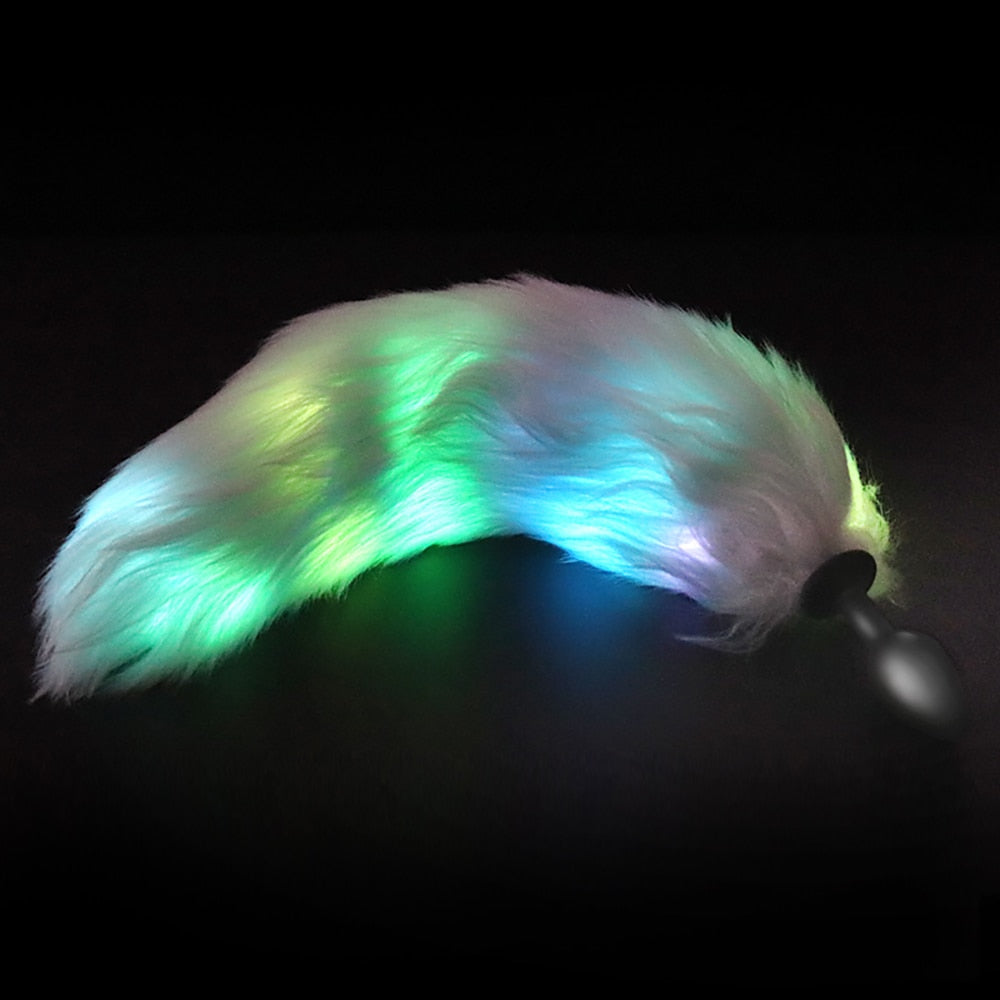 Glowing multicolor furry tail plug shown at an angle on a black background