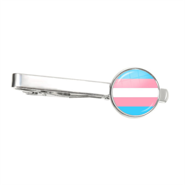 Silver tie clip with a round transgender pride flag emblem on a white background