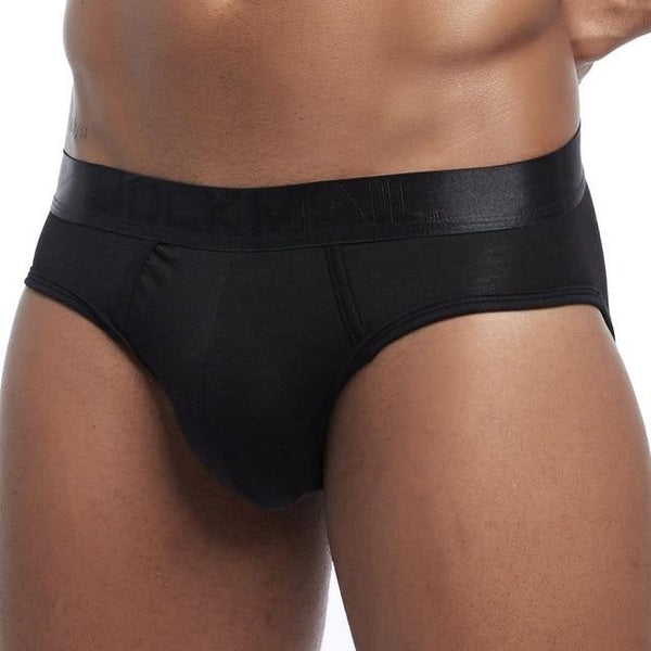 Front view of black minimalist briefs on a model, with a wide waistband and contoured pouch