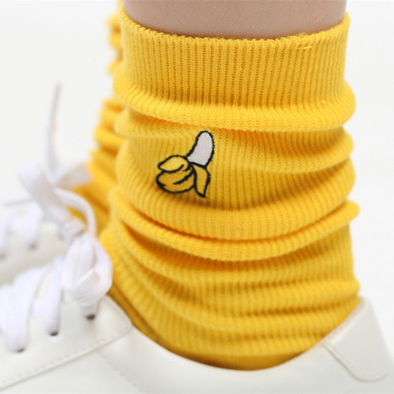 Close-up of a banana-yellow ribbed sock with a small banana graphic, worn with white sneakers