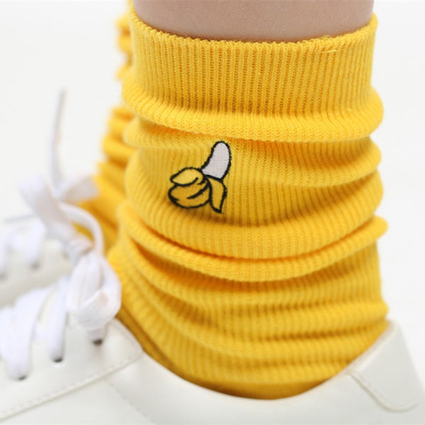 Close-up of a banana-yellow ribbed sock with a small banana graphic, worn with white sneakers