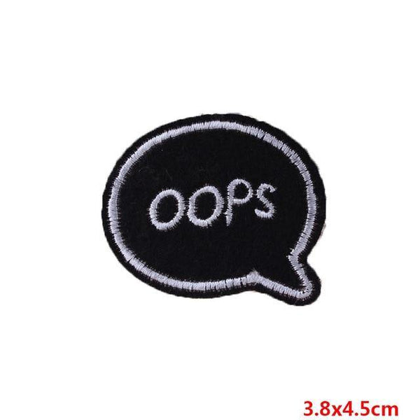 Black embroidered speech-bubble patch reading “OOPS,” with a 3.8 × 4.5 cm size label