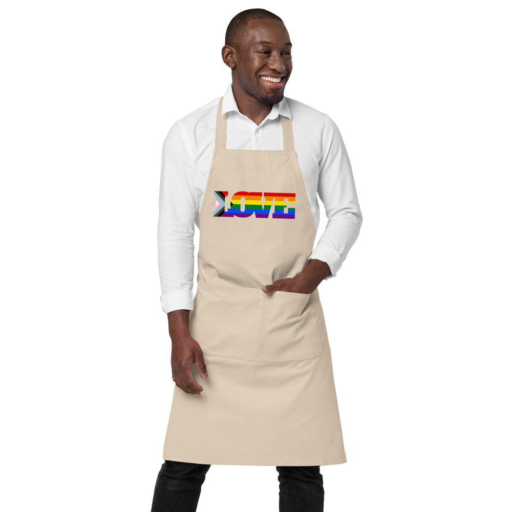 Front-view model wearing a beige apron with a rainbow-striped “LOVE” design and front pocket