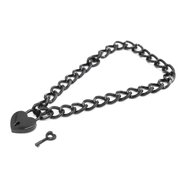 Close-up of a black chain collar with a heart-shaped padlock and separate key
