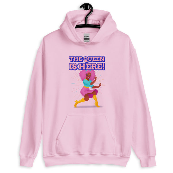Front view of a light pink hoodie reading “THE QUEEN IS HERE!” with a colorful dancing figure