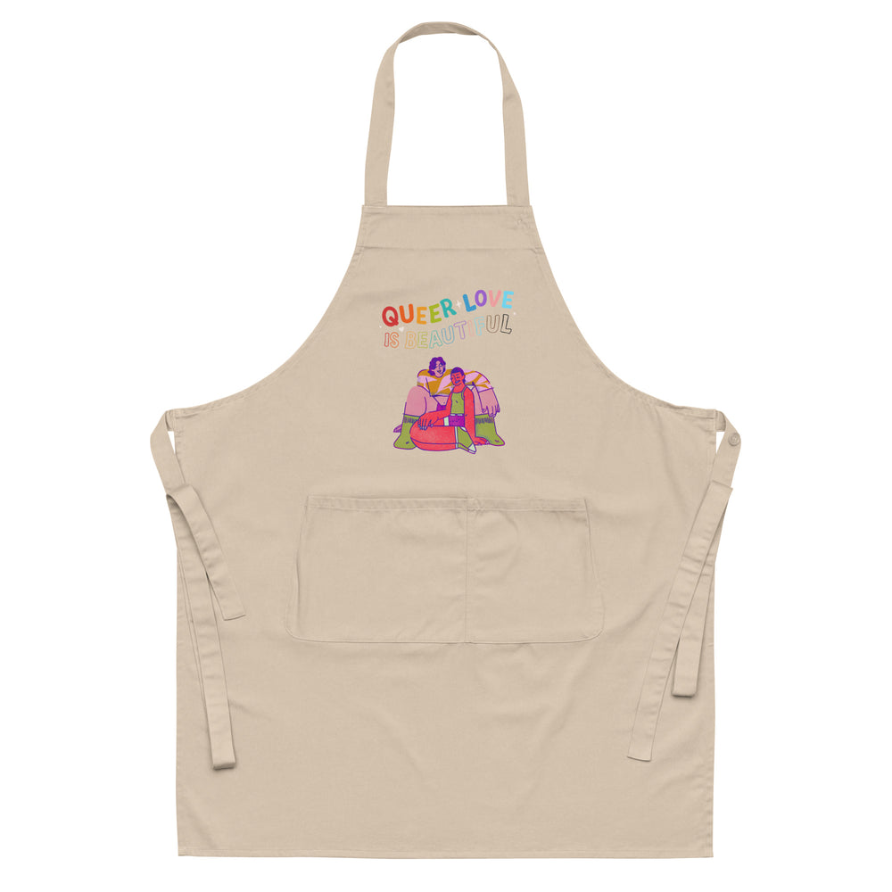 Front view of a beige apron reading “QUEER LOVE IS BEAUTIFUL,” with a colorful couple illustration and pocket.
