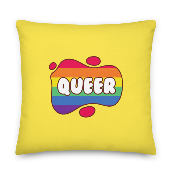 Square yellow pillow with a rainbow-striped speech bubble reading “QUEER”