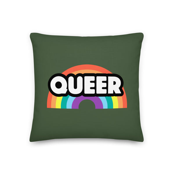 Dark green square pillow with a rainbow graphic and bold white “QUEER” lettering