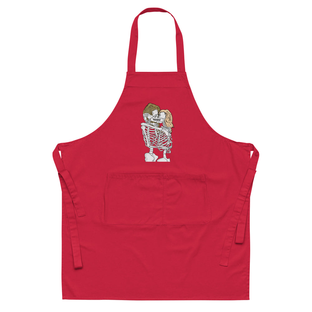 Front view of a red apron with a central illustration of two kissing skeletons and a large pocket