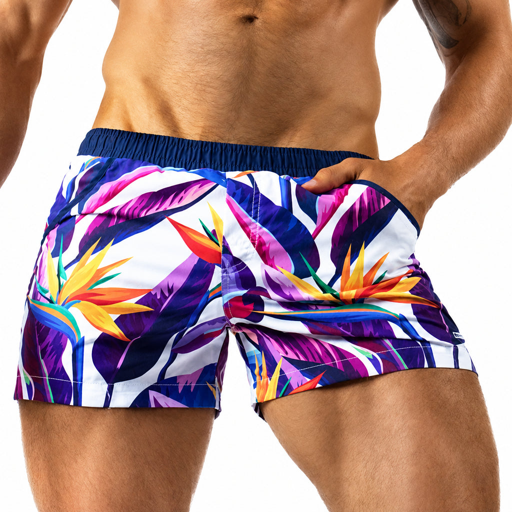 Close-up front view of a model wearing colorful bird-of-paradise print shorts