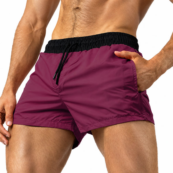 Front view of a model wearing maroon short shorts with a black elastic waistband