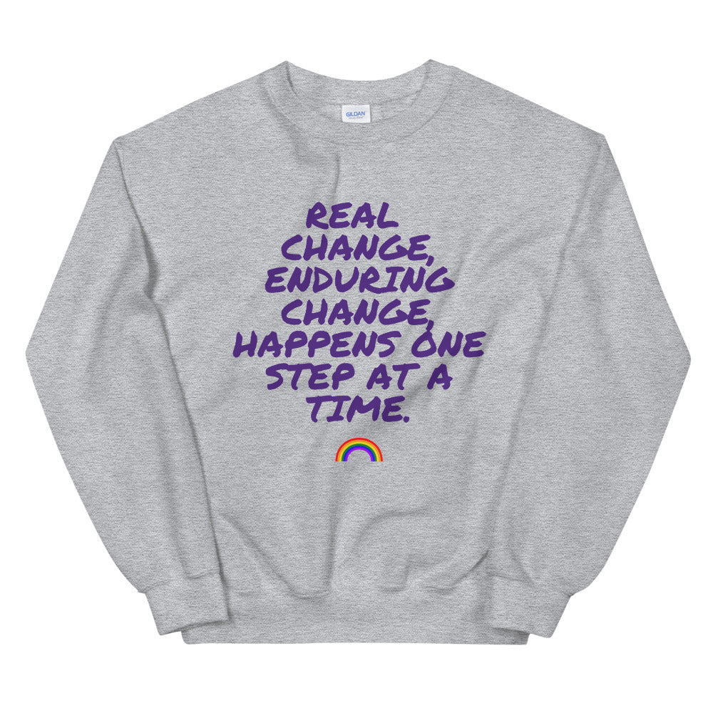 Gray unisex sweatshirt with purple “REAL CHANGE, ENDURING CHANGE” text and a rainbow graphic