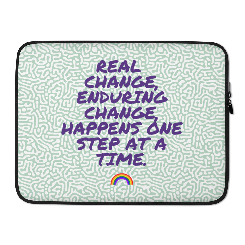 Laptop sleeve with purple “REAL CHANGE, ENDURING CHANGE, HAPPENS ONE STEP AT A TIME” lettering