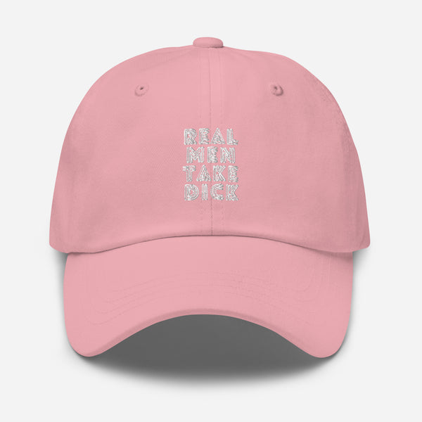 Front view of a pink cap embroidered with “REAL MEN TAKE DICK” in white
