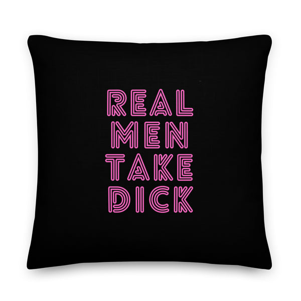Black square pillow with pink outlined text reading “REAL MEN TAKE DICK”