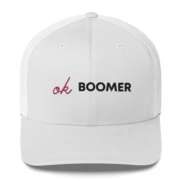 White trucker cap embroidered with the words “Ok Boomer” in black and pink
