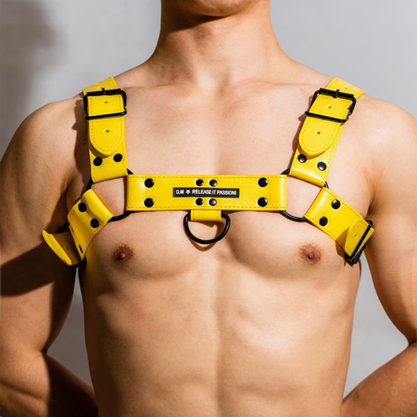 Front-facing model wearing a bright yellow leather chest harness with black hardware and a center O-ring