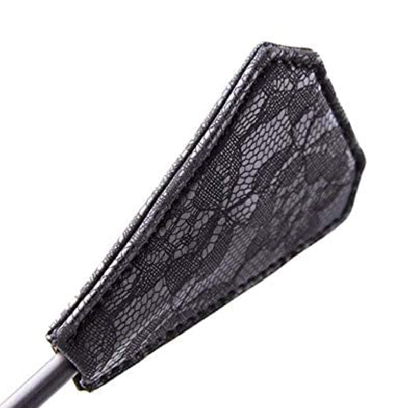 Close-up of a black lace-covered, tapered paddle attached to a handle