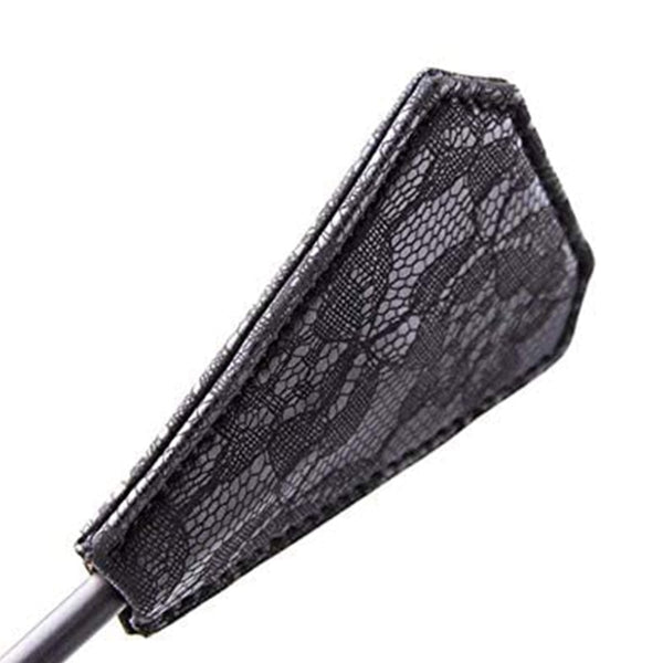 Close-up of a black lace-covered, tapered paddle attached to a handle