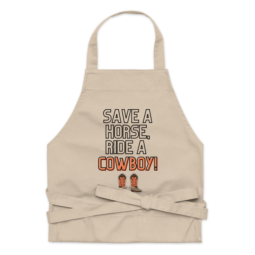 Front view of a beige apron reading “SAVE A HORSE, RIDE A COWBOY!” with cowboy boots