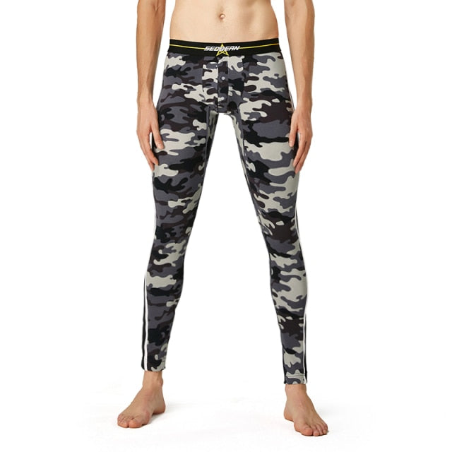 Gray, black, and white camouflage thermal leggings modeled with a black waistband