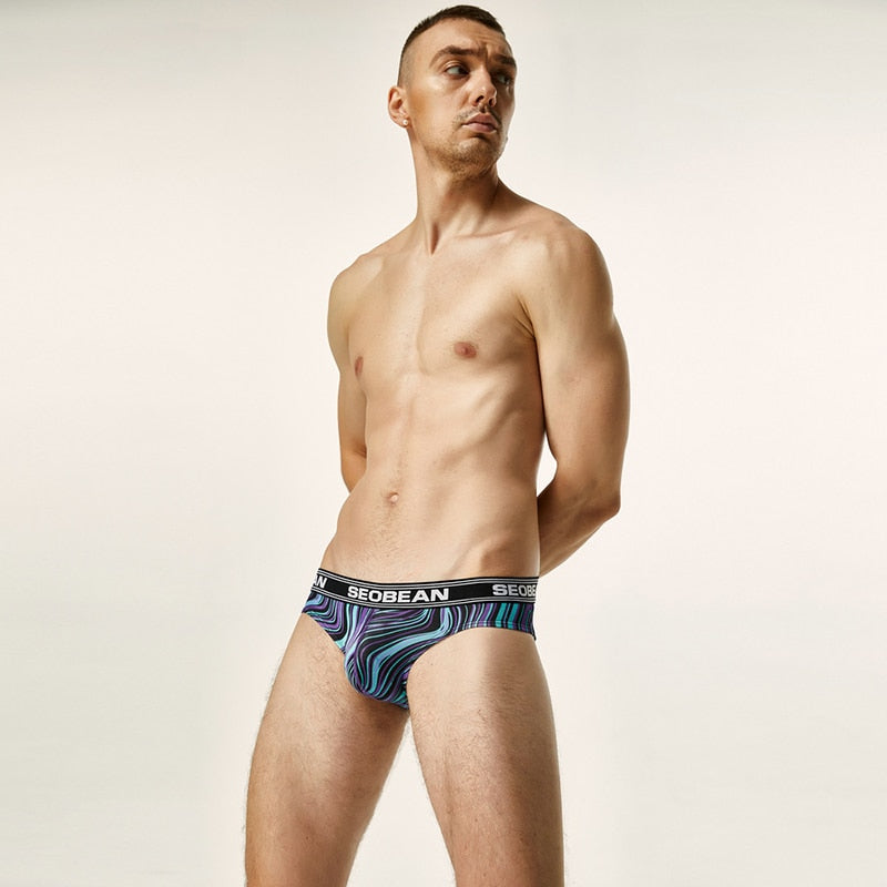 Model wearing black briefs with colorful swirling stripes and a SEOBEAN logo waistband