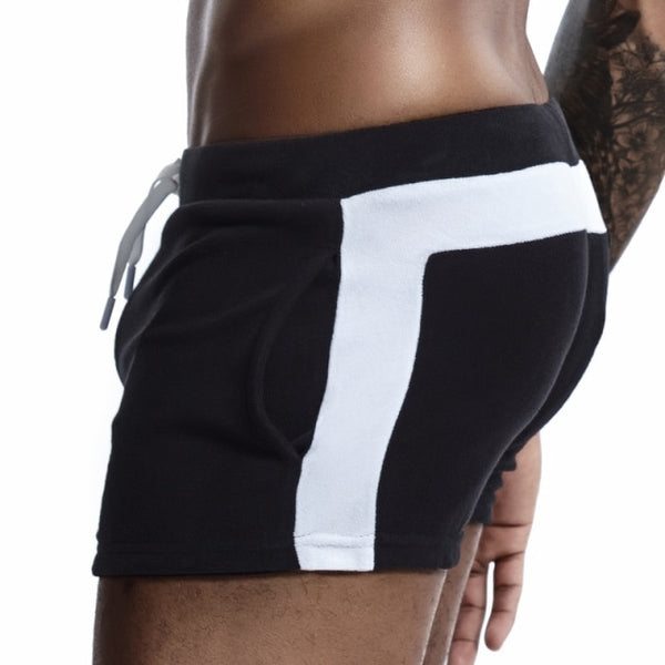 Close rear-side view of black velour shorts with a wide white side stripe