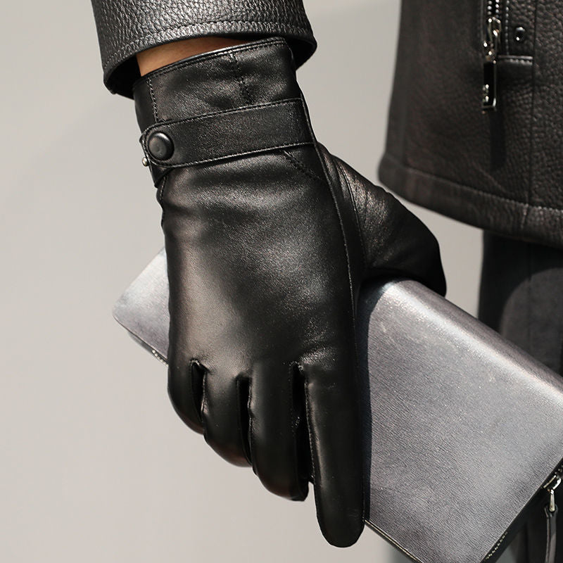 Close-up of a black leather glove with a snap wrist strap on a silver chair